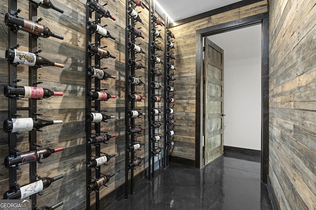 wine cellar featuring concrete floors and wood walls