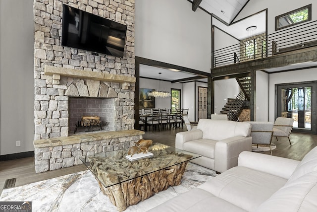 living room with a stone fireplace, hardwood / wood-style floors, and high vaulted ceiling