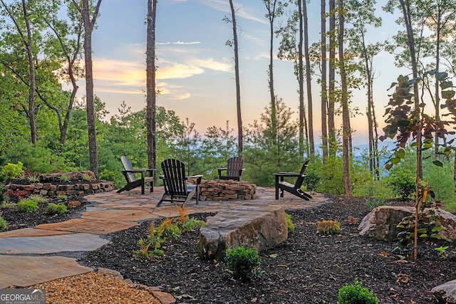 patio terrace at dusk featuring an outdoor fire pit