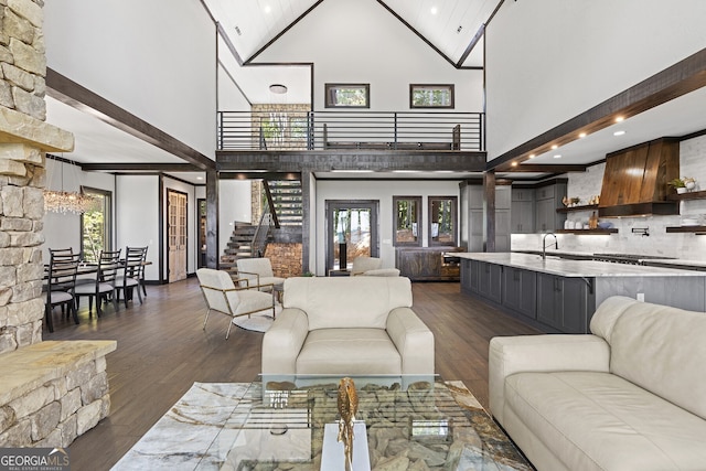 living room featuring a chandelier, high vaulted ceiling, beamed ceiling, dark wood-type flooring, and sink