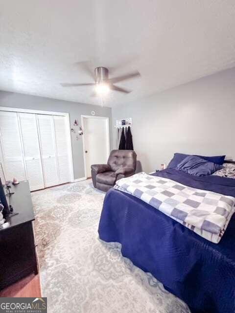 bedroom with a closet, ceiling fan, and carpet floors