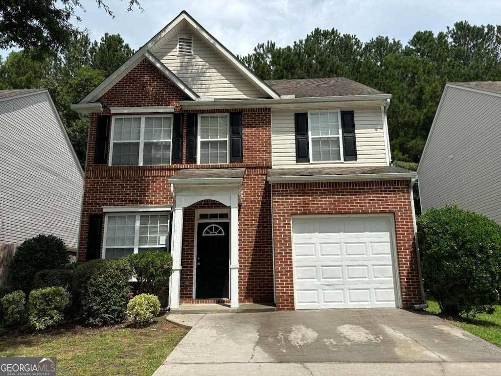 traditional-style home with a garage, concrete driveway, and brick siding