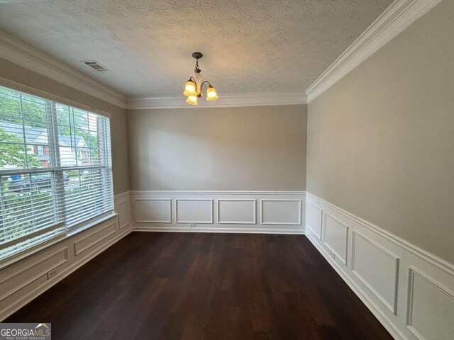 spare room with crown molding, dark hardwood / wood-style flooring, a textured ceiling, and a chandelier