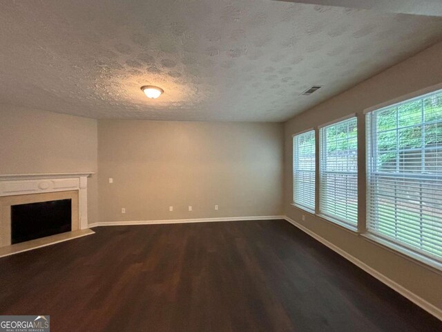 unfurnished living room with a textured ceiling, a high end fireplace, and hardwood / wood-style flooring