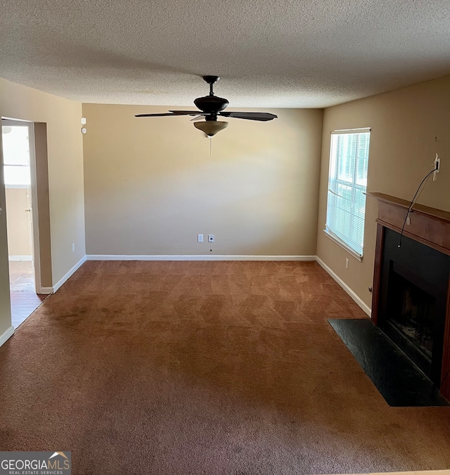 unfurnished living room with a textured ceiling, carpet, and ceiling fan