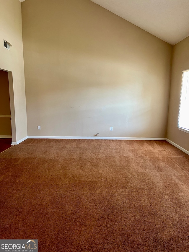 spare room featuring lofted ceiling and light carpet