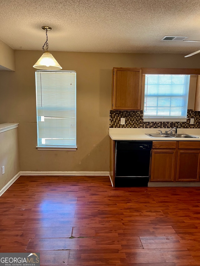 kitchen featuring dishwasher, wood-type flooring, sink, and hanging light fixtures