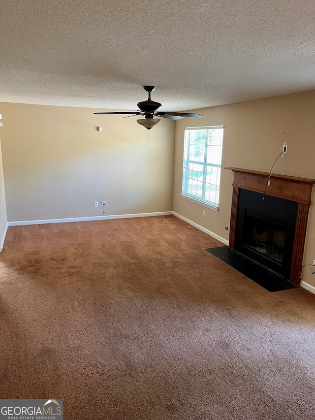 unfurnished living room featuring ceiling fan, carpet, and a textured ceiling