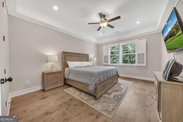 bedroom with ceiling fan, light wood-type flooring, and crown molding