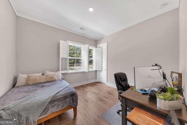 bedroom featuring crown molding and hardwood / wood-style flooring