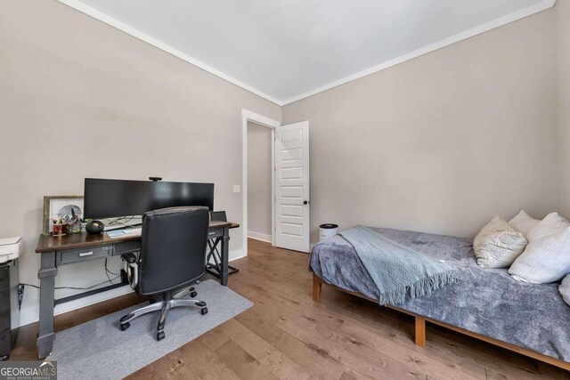 bedroom featuring wood-type flooring and crown molding