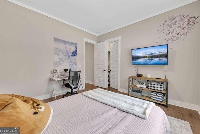 bedroom featuring ornamental molding and hardwood / wood-style flooring