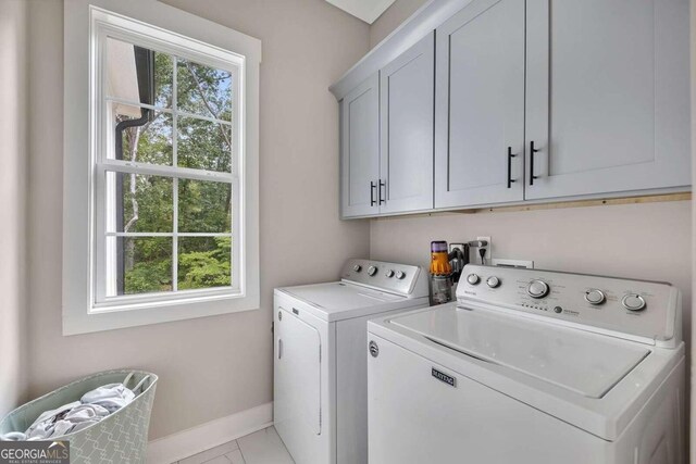 laundry area featuring light tile patterned floors, cabinets, and separate washer and dryer