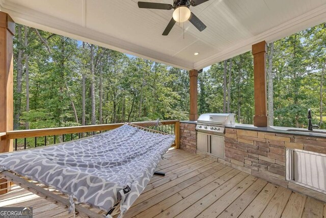 wooden terrace featuring ceiling fan, sink, grilling area, and area for grilling