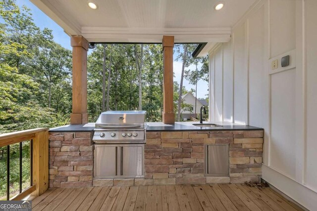 exterior space featuring grilling area, sink, and an outdoor kitchen