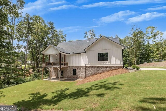 back of house featuring a patio area and a lawn