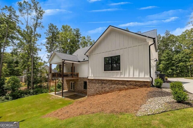 view of side of home with a deck and a yard