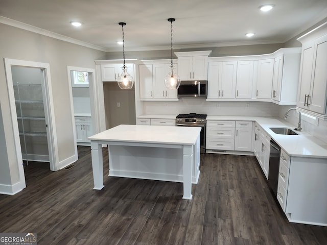 kitchen featuring pendant lighting, a center island, white cabinetry, stainless steel appliances, and sink