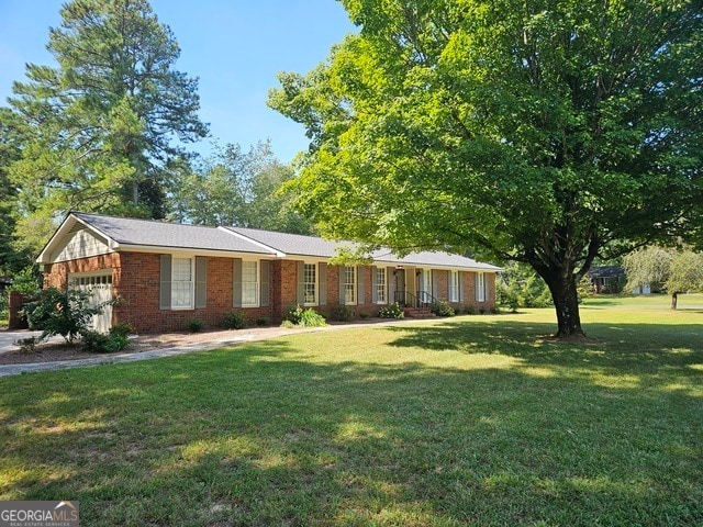 ranch-style house featuring a front lawn and a garage