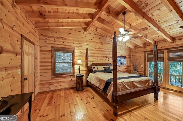 bedroom with light wood-type flooring, wood ceiling, and wooden walls