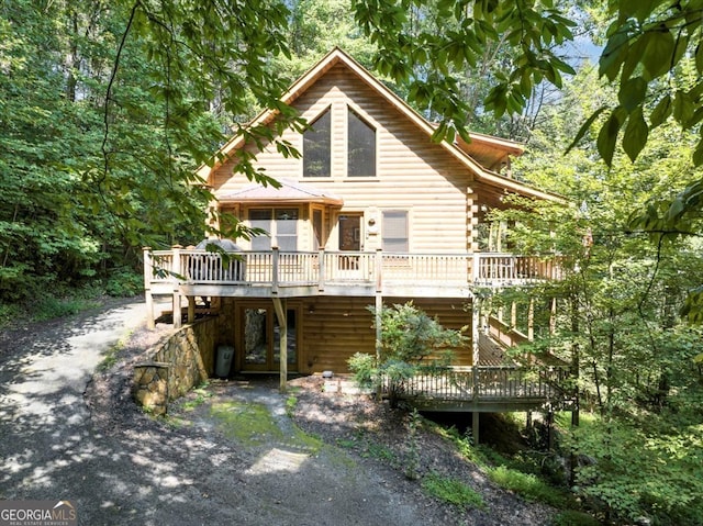 rear view of property featuring a wooden deck