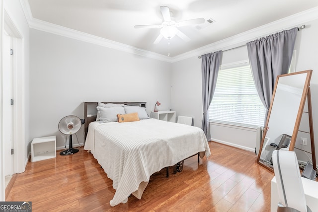 bedroom featuring crown molding, ceiling fan, and hardwood / wood-style flooring