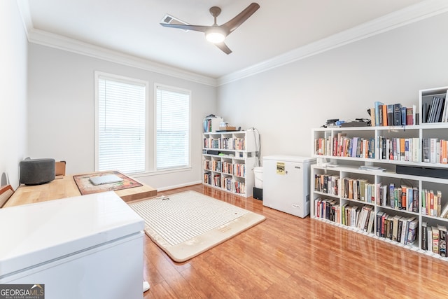 interior space featuring light hardwood / wood-style floors, ornamental molding, and ceiling fan