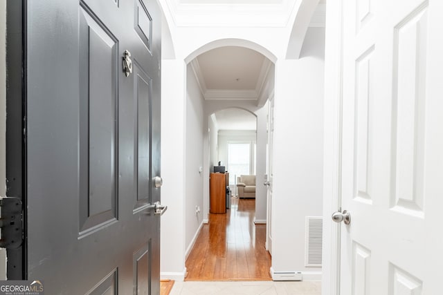 hallway featuring light wood-type flooring and crown molding