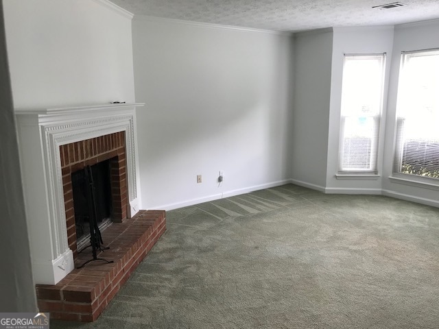 unfurnished living room featuring a textured ceiling, a fireplace, carpet, and crown molding