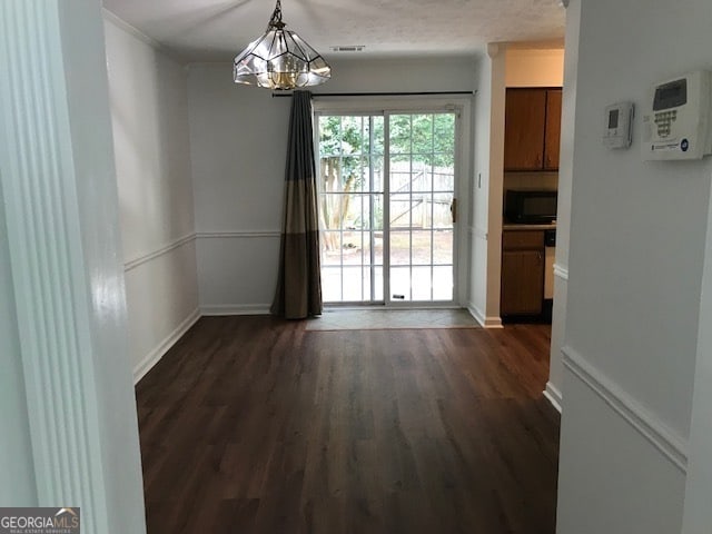 interior space with dark wood-type flooring and a chandelier