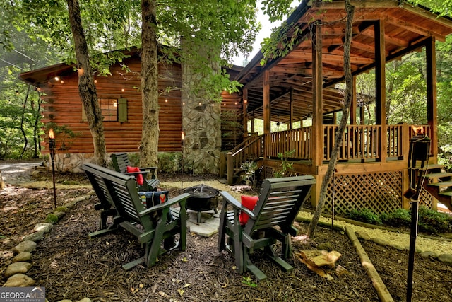 exterior space featuring an outdoor fire pit and a wooden deck