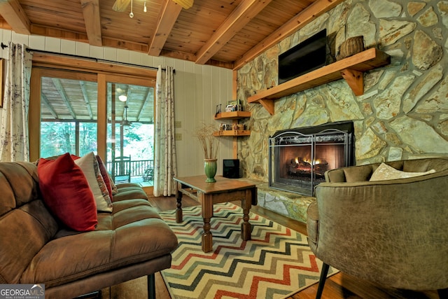 living room featuring beam ceiling, a fireplace, wood ceiling, and hardwood / wood-style floors