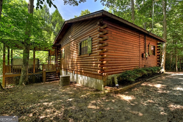 view of side of home with a wooden deck and central air condition unit