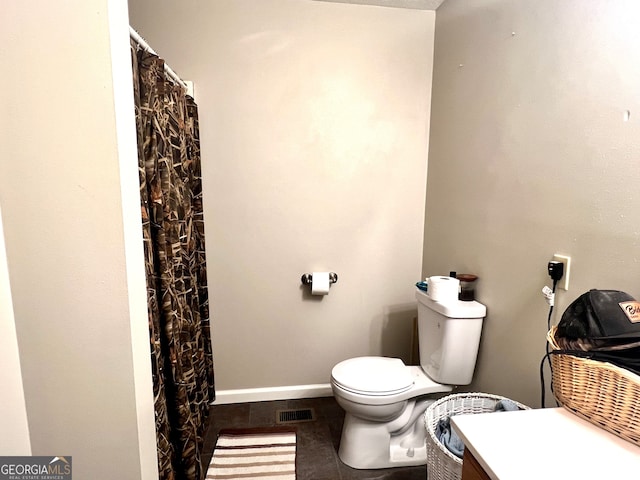 bathroom featuring vanity, tile patterned flooring, and toilet