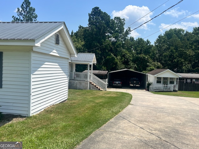 view of side of property featuring a lawn and a carport
