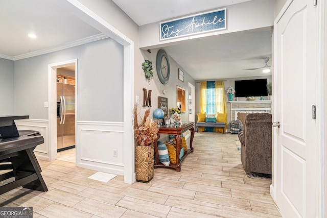 hallway with ornamental molding, wood finish floors, and wainscoting