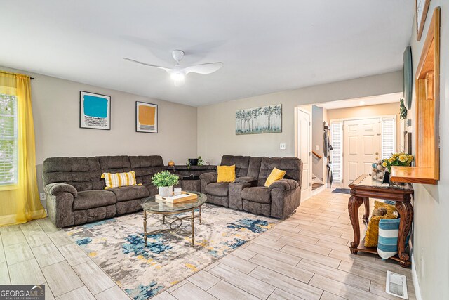 living area featuring wood tiled floor, visible vents, and a ceiling fan