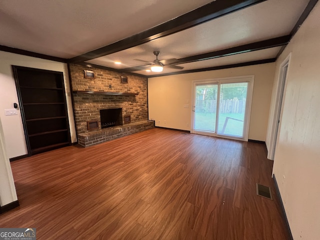 unfurnished living room featuring beamed ceiling, ceiling fan, hardwood / wood-style flooring, and a brick fireplace