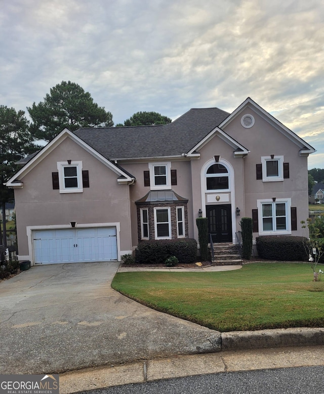 front facade featuring a garage and a front lawn