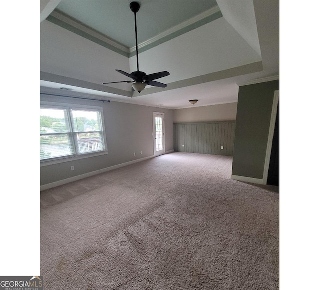 unfurnished room featuring carpet flooring, a tray ceiling, ornamental molding, and ceiling fan