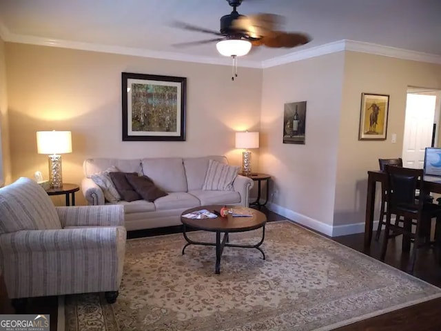 living room featuring ceiling fan, ornamental molding, and wood-type flooring