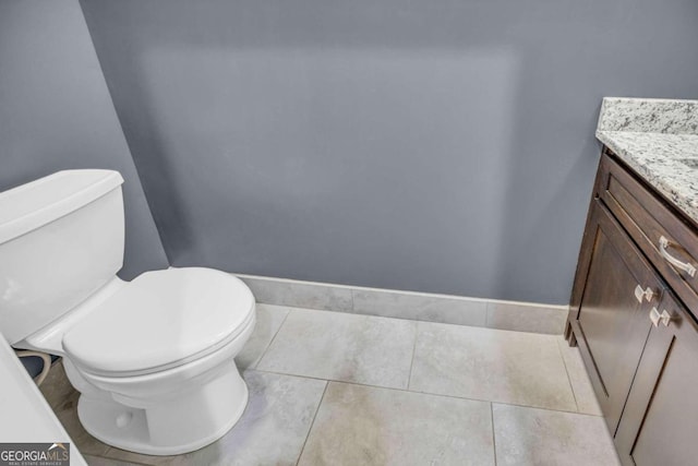 half bath featuring toilet, vanity, and tile patterned floors