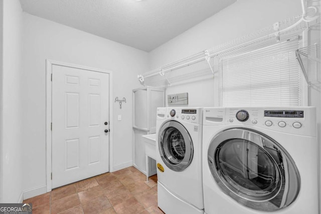 laundry area with washing machine and dryer and a textured ceiling