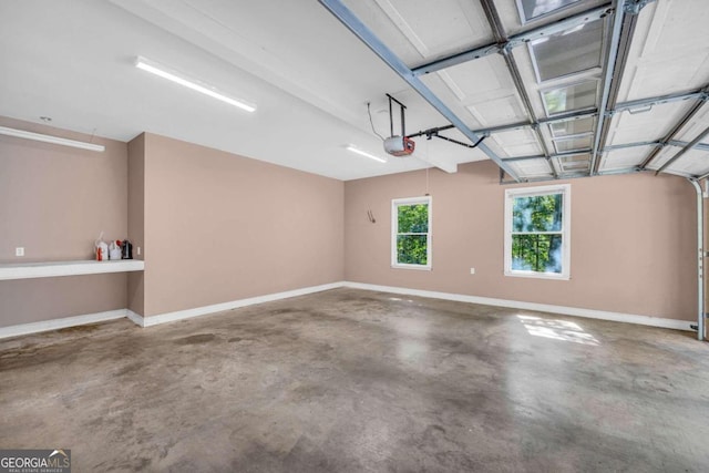 garage with baseboards and a garage door opener