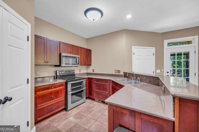 kitchen featuring light stone counters, light tile patterned flooring, stainless steel appliances, a peninsula, and a sink