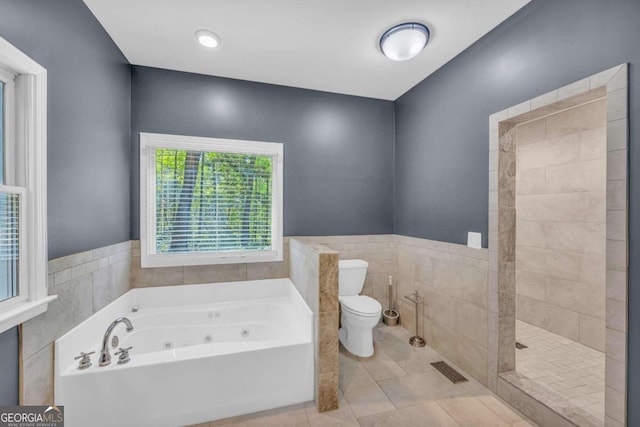 full bathroom featuring toilet, a tub with jets, tile patterned floors, a tile shower, and tile walls