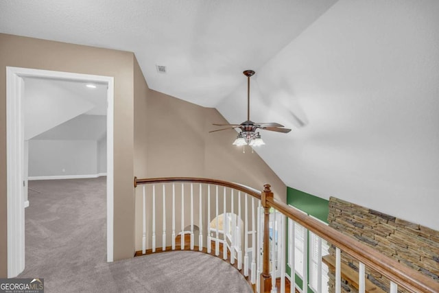 stairs featuring lofted ceiling, carpet flooring, and ceiling fan