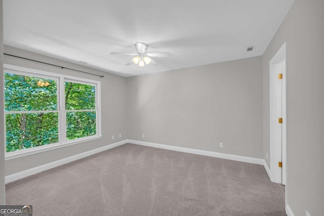 unfurnished room featuring carpet, visible vents, baseboards, and ceiling fan