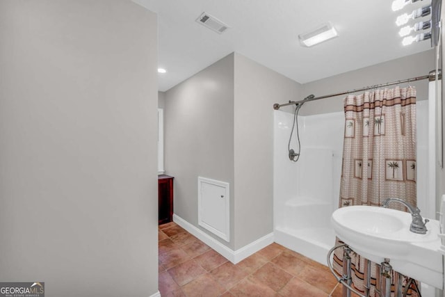 full bath featuring visible vents, a sink, a shower with curtain, baseboards, and tile patterned floors