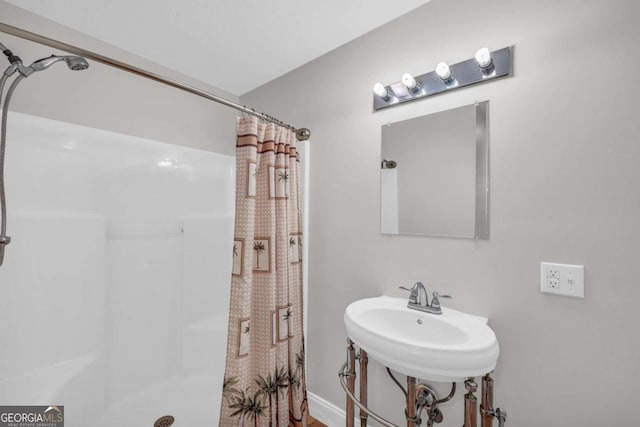 bathroom featuring curtained shower and a sink